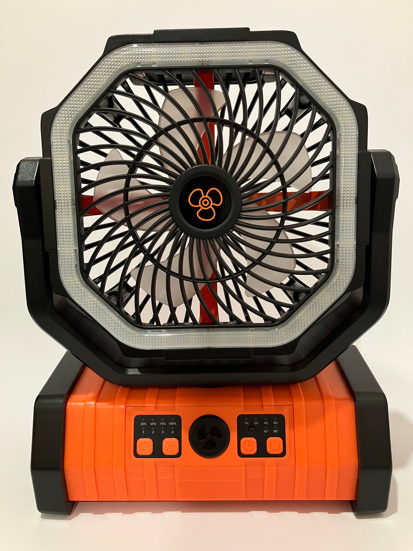 A compact portable fan with a black and orange design, featuring a front grille with visible fan blades and a side control panel with buttons, shown against a plain light background.