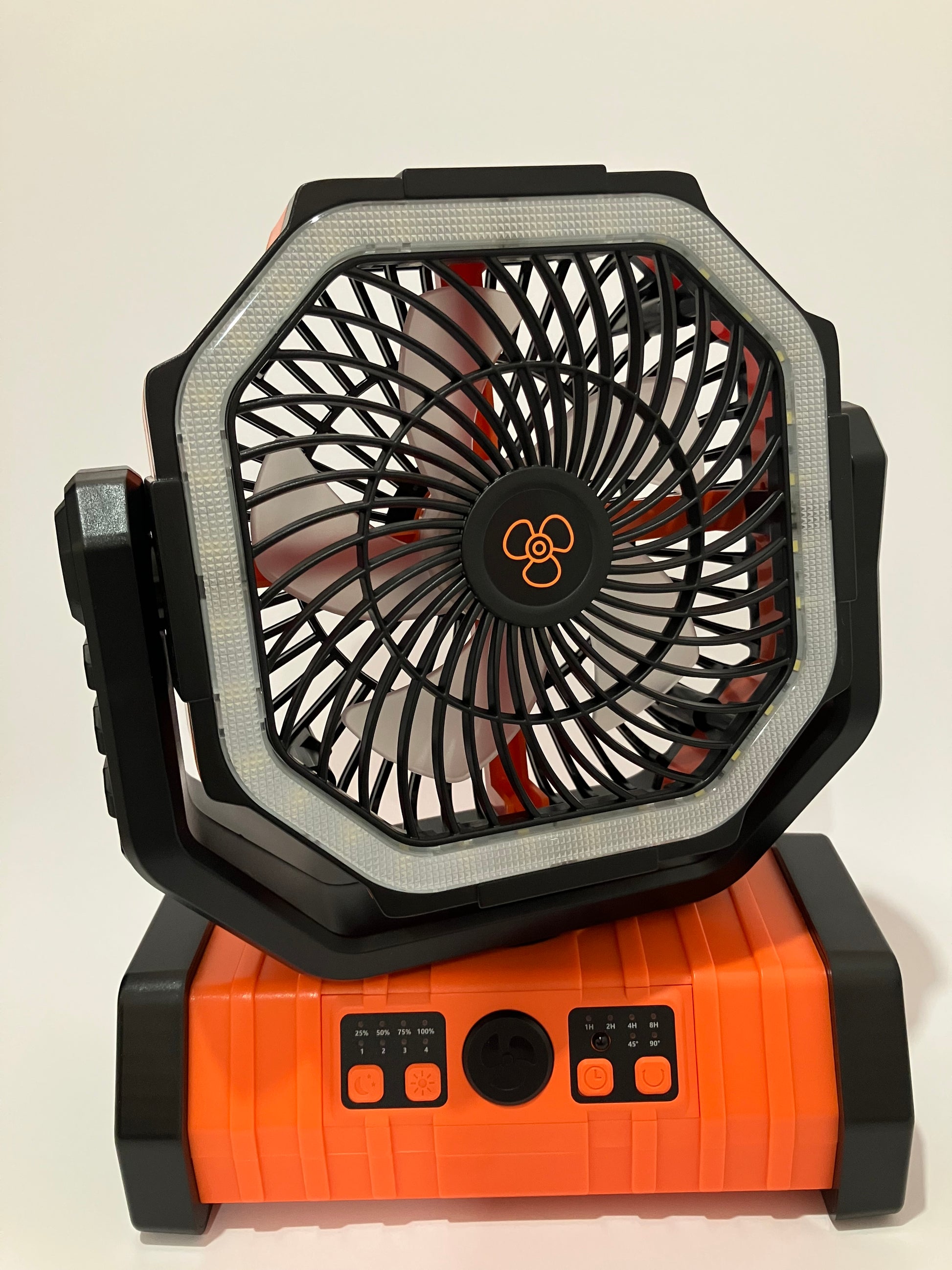 A portable octagonal fan and light combo with a black and orange design, featuring a built-in LED light ring around the fan blades.